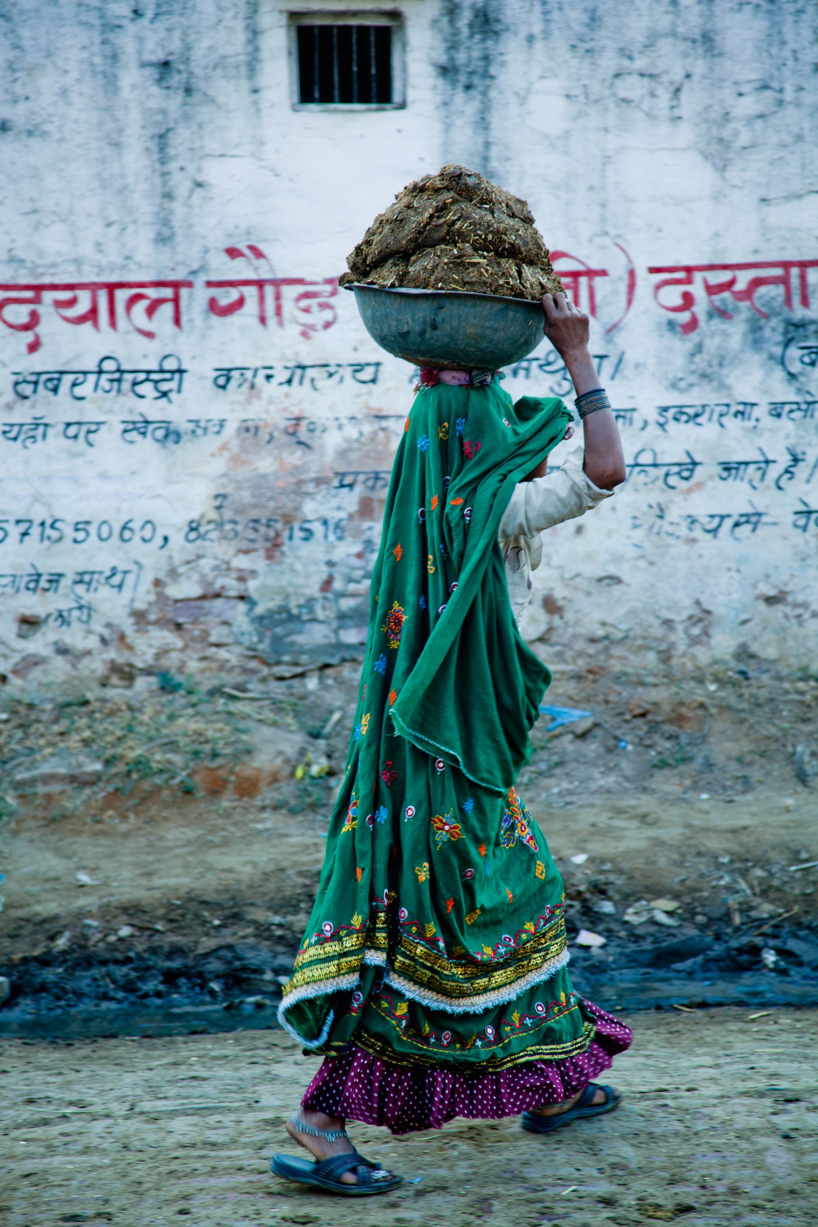 Photographie d&rsquo;art d&rsquo;Andr&eacute; Wagner: A woman carrying cow dung that she has collected for fuel.