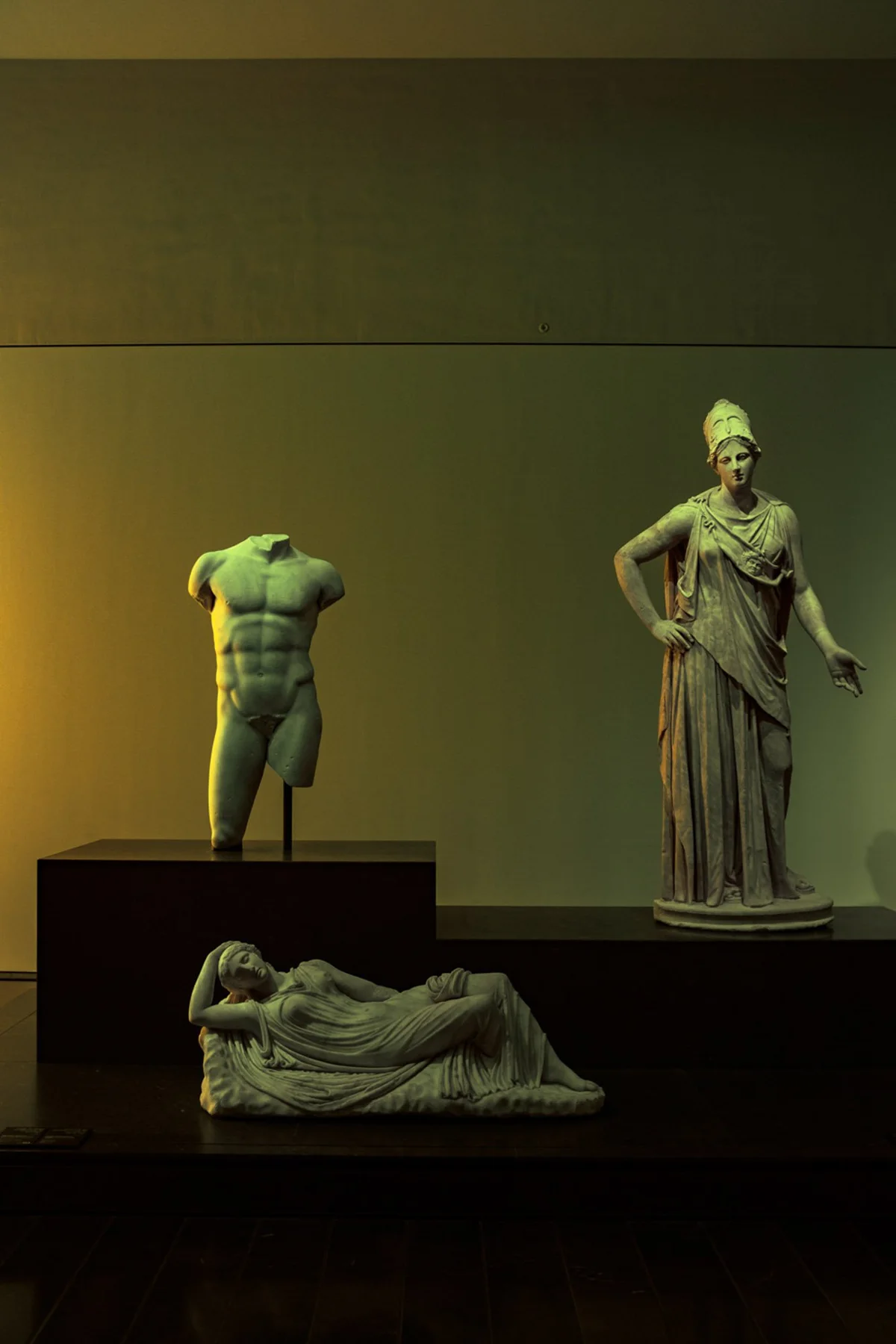 Sculptures antiques dans une salle d&rsquo;exposition assombrie.