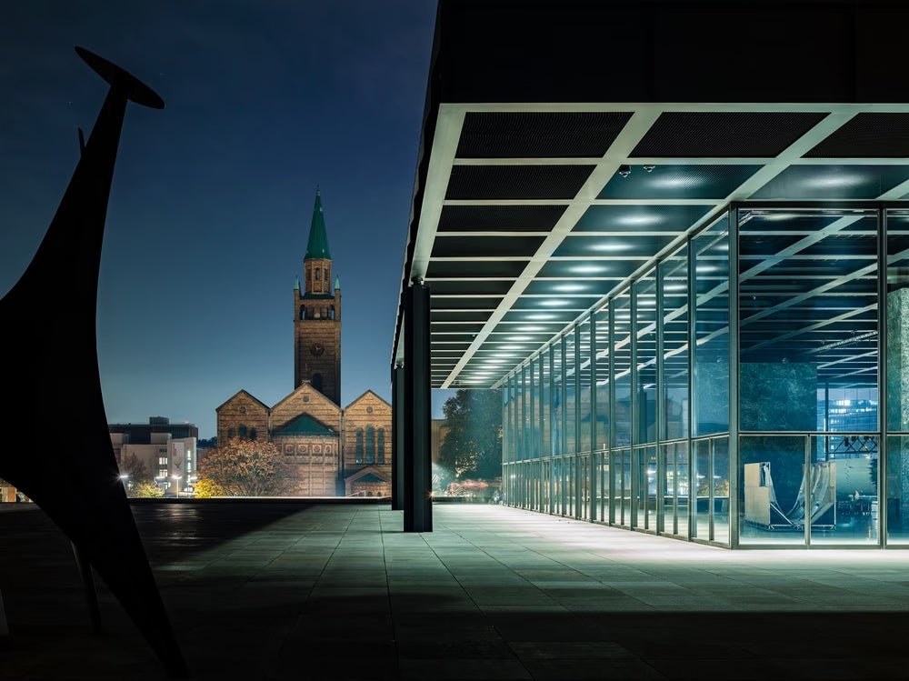 Fine art photography by André Wagner: A glass facade and broad dark roof recede from the right — Blue Art Treasure Chest, Deutschland.