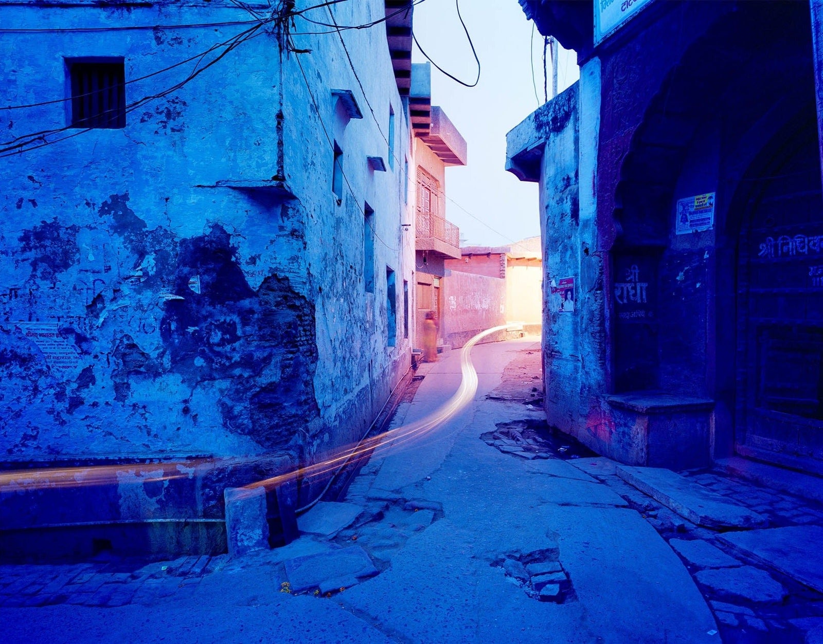 Photographie d’art d’André Wagner: Des murs bleus encadrent une ruelle étroite et courbe — Blue street corner, Indien.