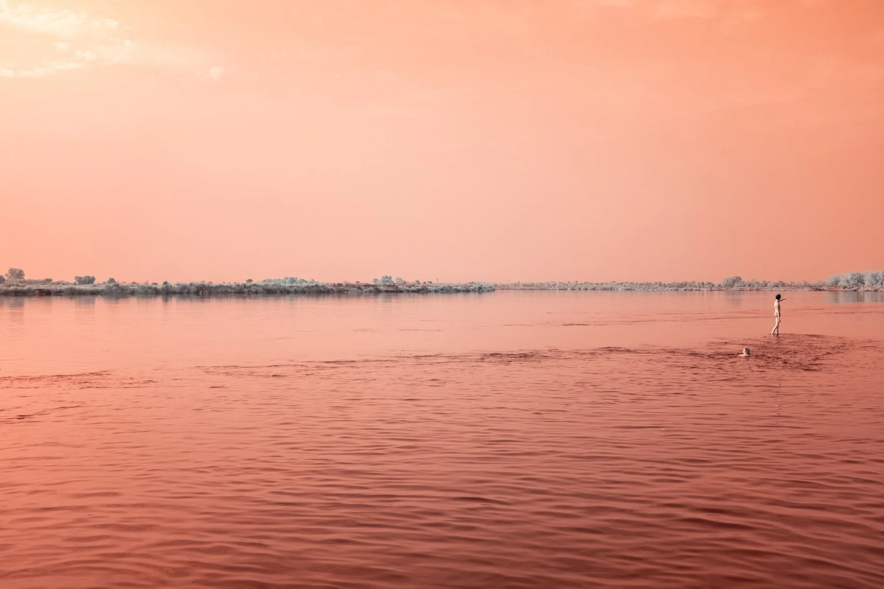Large fleuve sous un ciel orange.