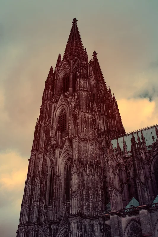 Photographie d’art infrarouge d’André Wagner: Vu de très près, le clocher s’élève et s’amincit dans un ciel jaune-vert atténué — Cologne Cathedral.