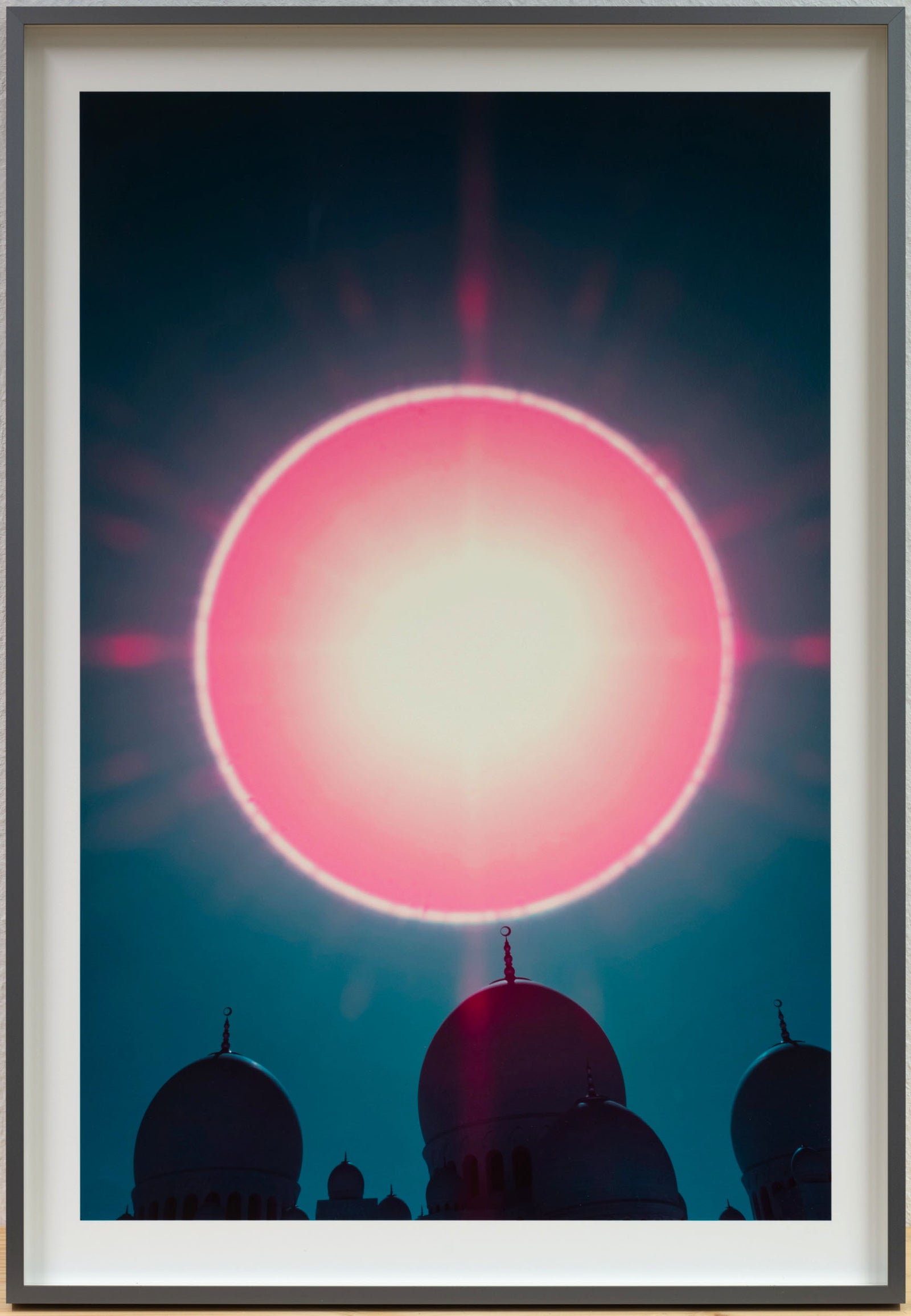 Photographie d’art infrarouge d’André Wagner: Un grand cercle rose-rouge se tient au-dessus des silhouettes sombres de coupoles — Cosmic crown: over the sheikh zayed grand mosque.