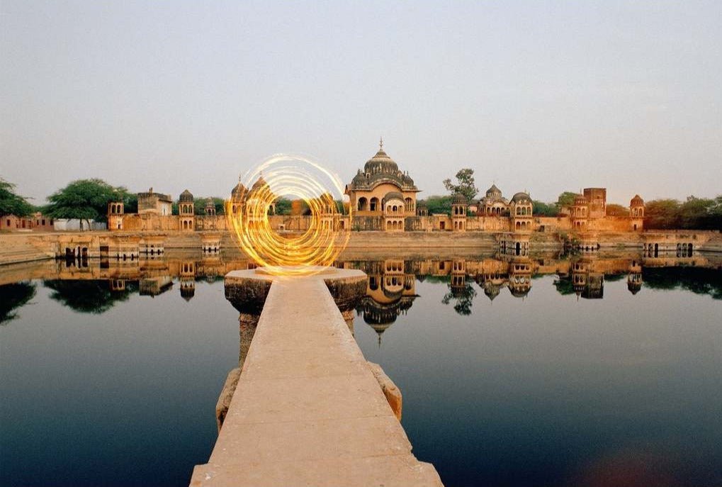 Fotokunst von André Wagner: Ein schmaler heller Steg führt genau aus der Bildmitte auf einen goldenen Lichtkreis zu — Dimension door, Indien.