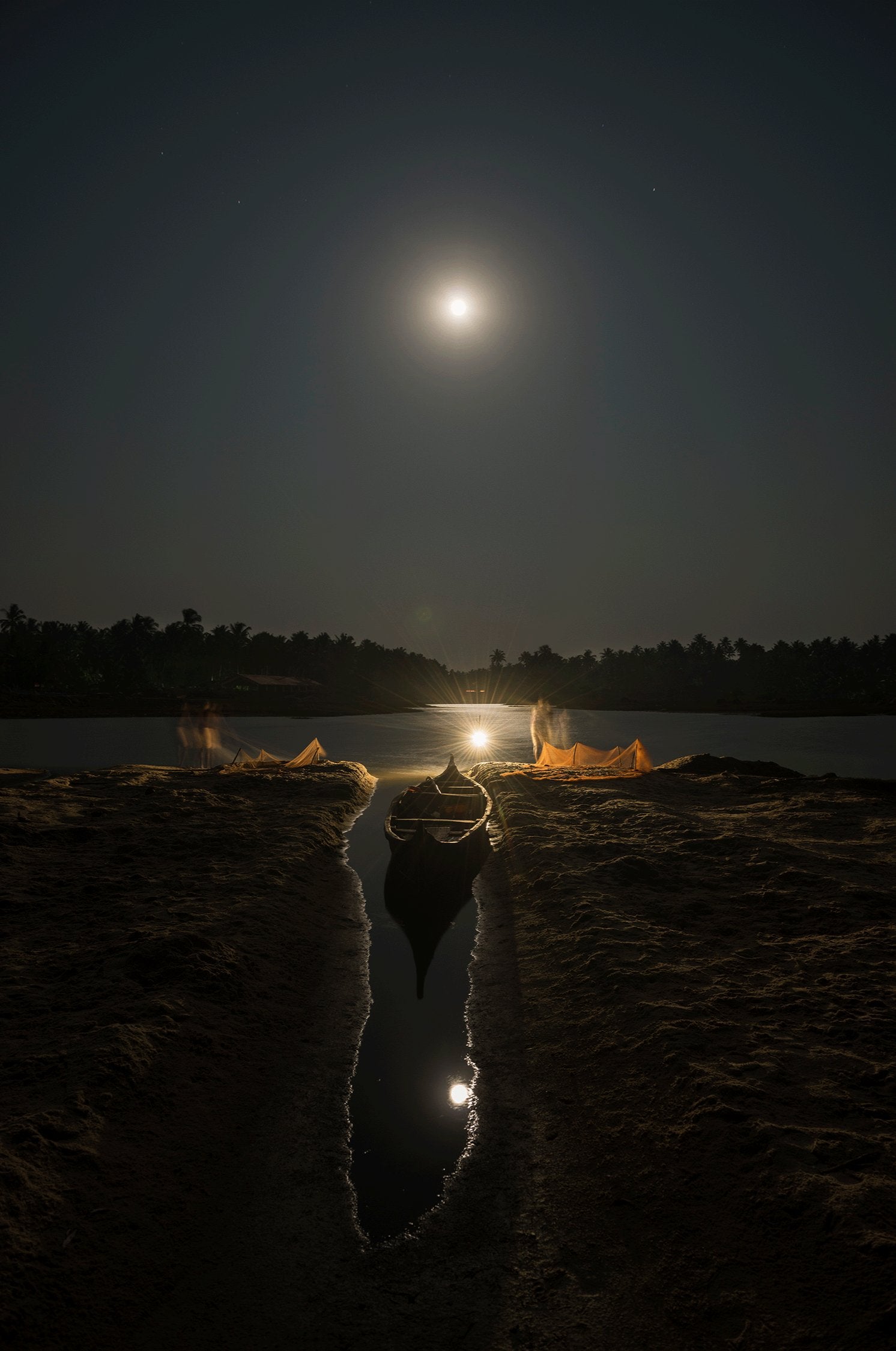 Photographie d’art d’André Wagner: Bien au-dessus d’une rive sombre, la lune apparaît comme un petit point clair — Fisherman's boat, Indien.