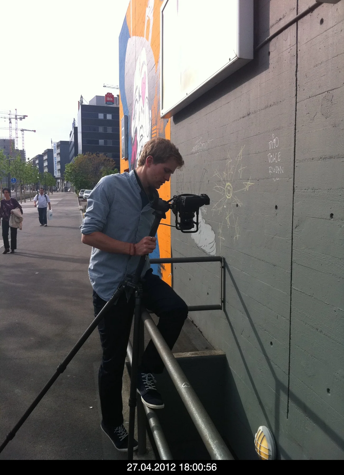 Photographer using a camera on a tripod in an urban setting