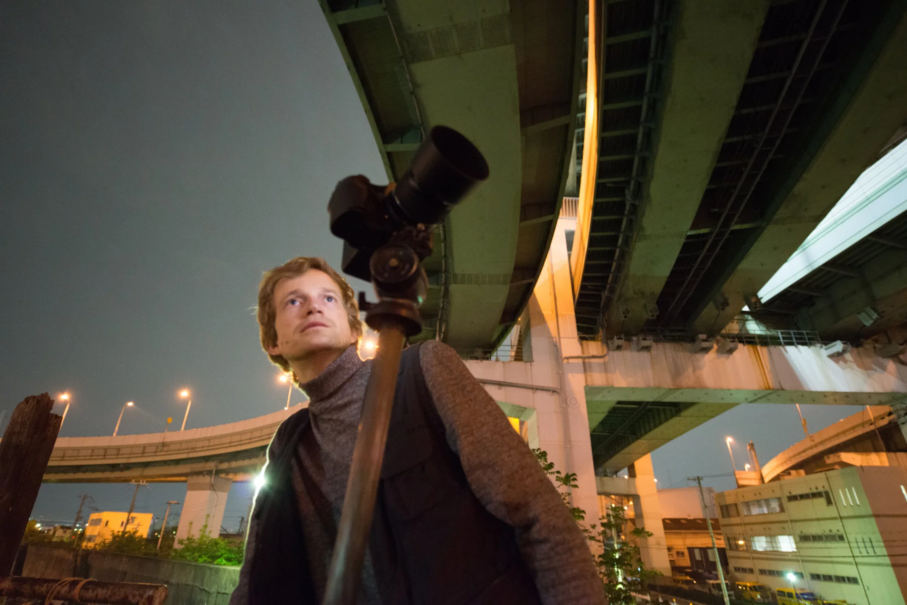 Photographe avec son appareil sous un m&eacute;tro a&eacute;rien la nuit