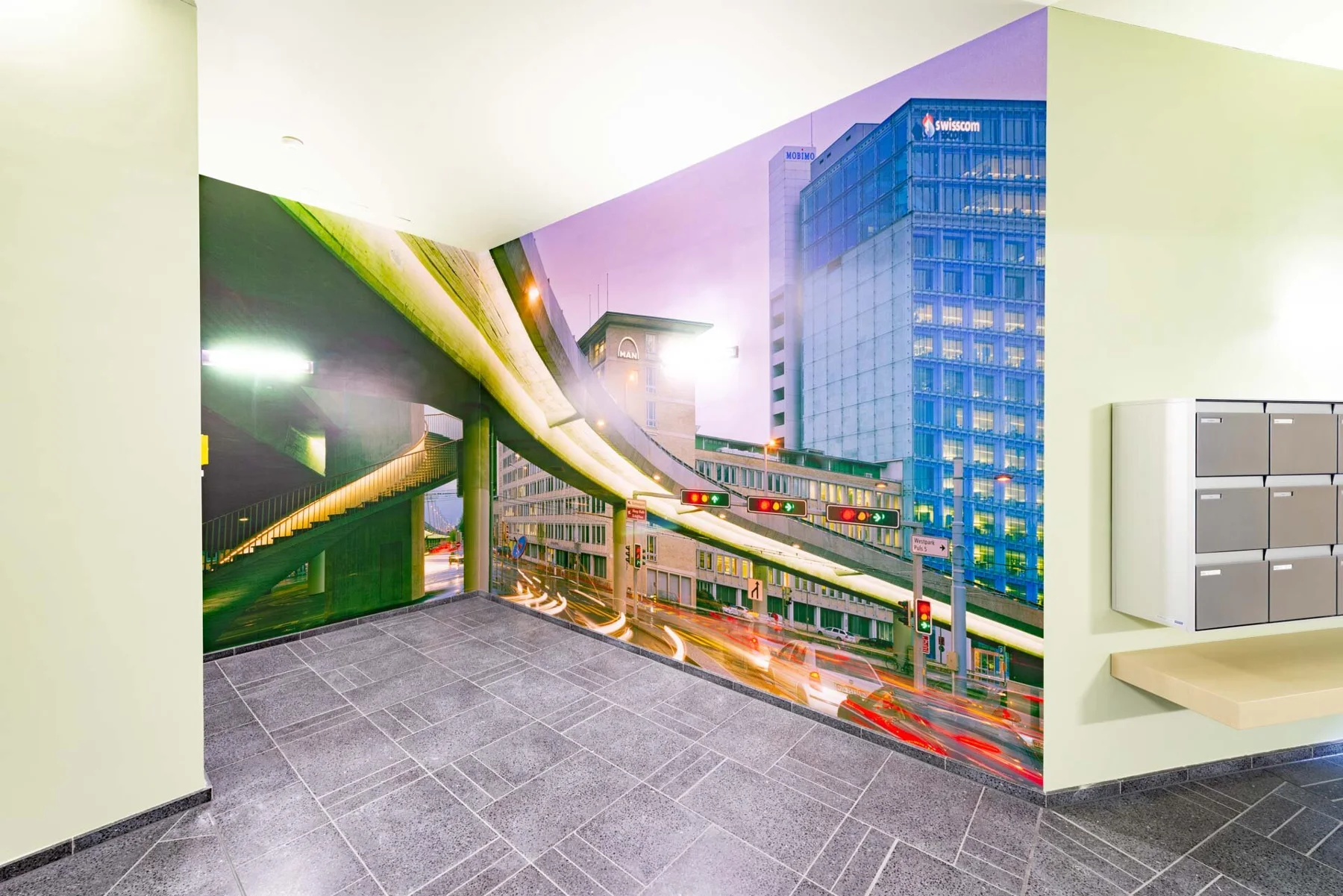 Large urban photographic artwork featuring an elevated railway in an entrance hall