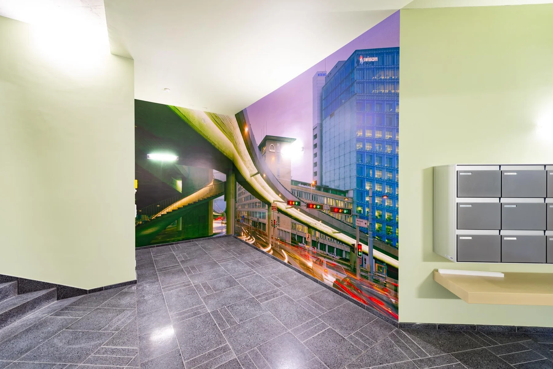 Large urban photographic artwork featuring an elevated railway in an entrance hall