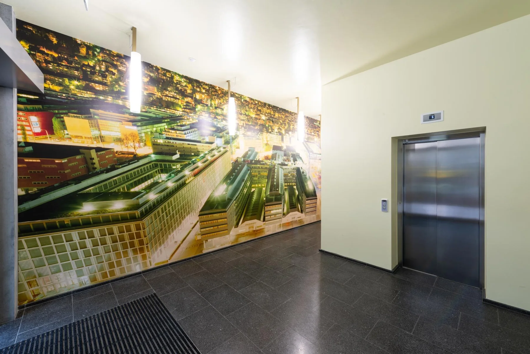 Large urban photographic artwork with roads and light trails in an entrance hall