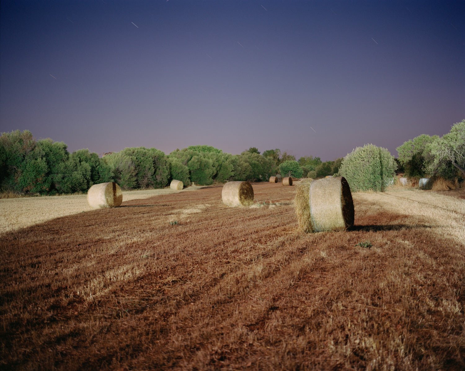 Photographie d’art d’André Wagner: Des balles de foin rondes se répartissent dans un champ moissonné — Hay Rolls, Spanien.