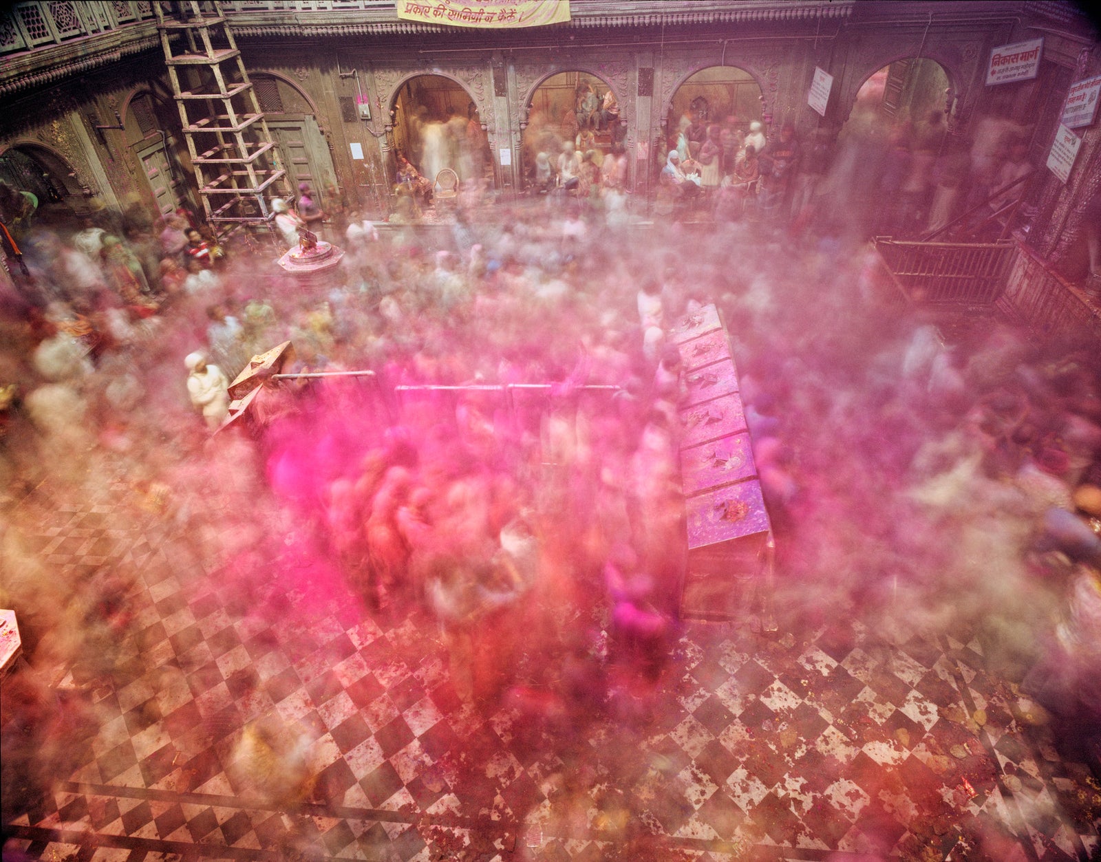 Photographie d’art d’André Wagner: Vue d’en haut, une foule nombreuse remplit une cour fermée — Holi Banke Bihari Temple 2, Indien.