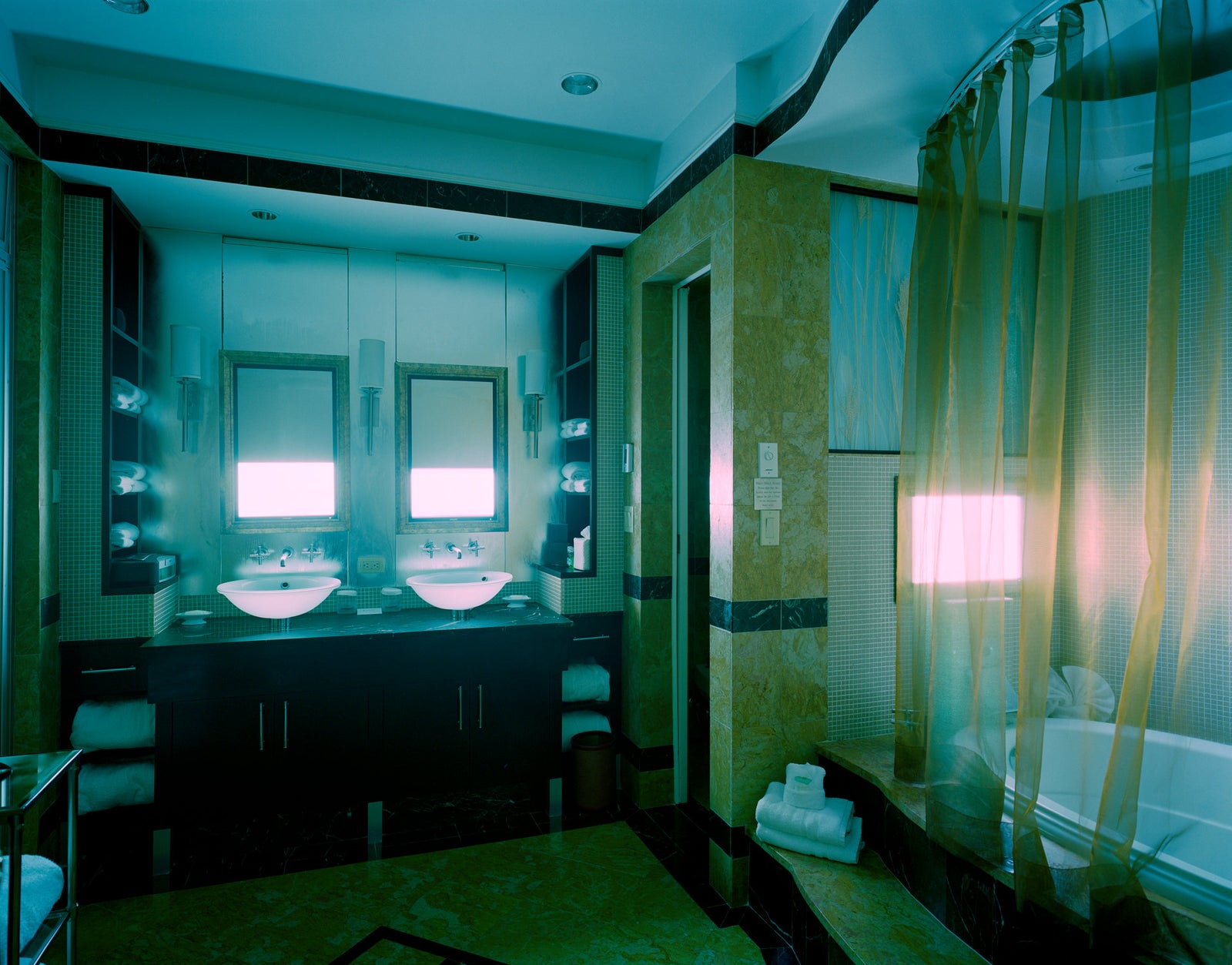 Photographie d’art d’André Wagner: Deux lavabos et deux miroirs forment un centre rigoureusement dédoublé — Hotel Room in New York 5.