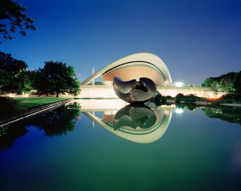 Photographie d’art d’André Wagner: Un toit clair aux lignes courbes se détache sur un ciel bleu profond — House of the Cultures of the World.