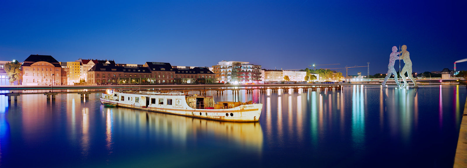 Photographie d’art d’André Wagner: Un bateau clair se tient en travers devant la rive opposée — Media Spree.