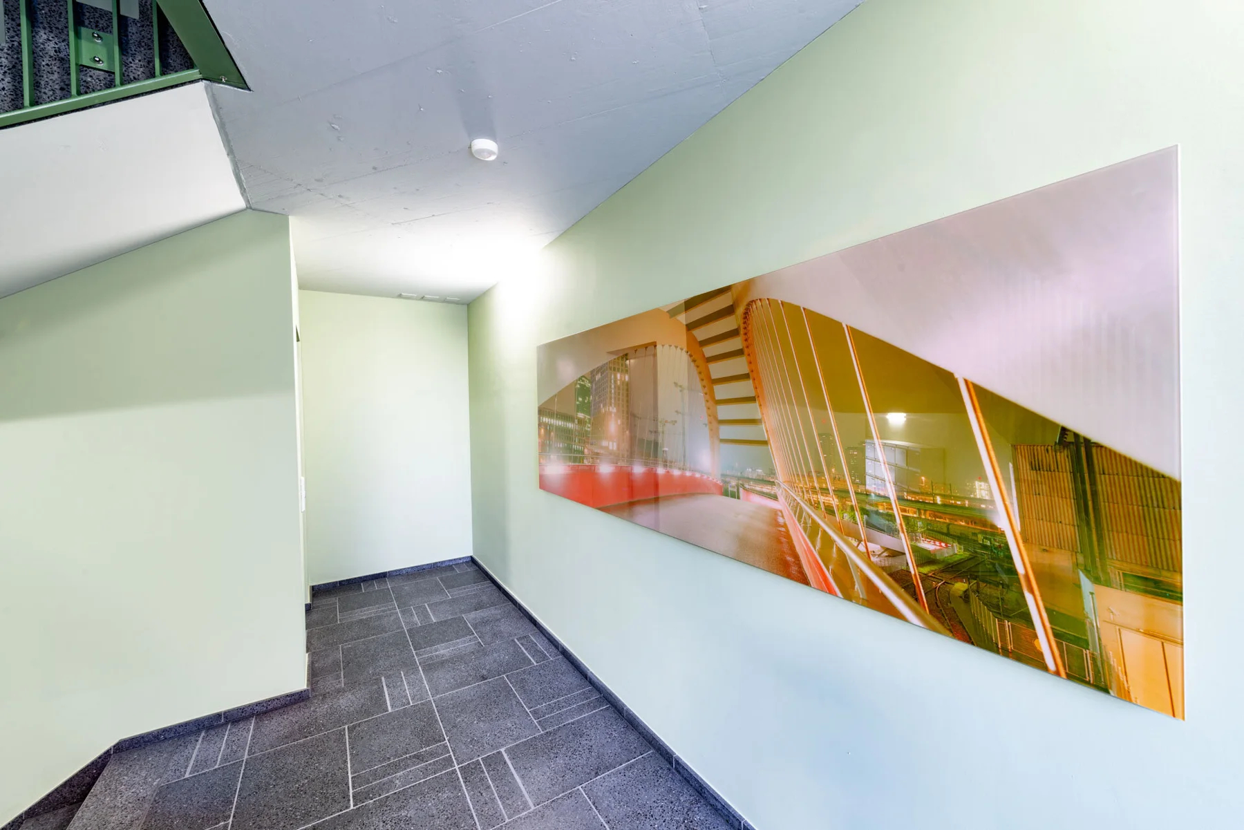 Panoramic photographic artwork beside a stair railing