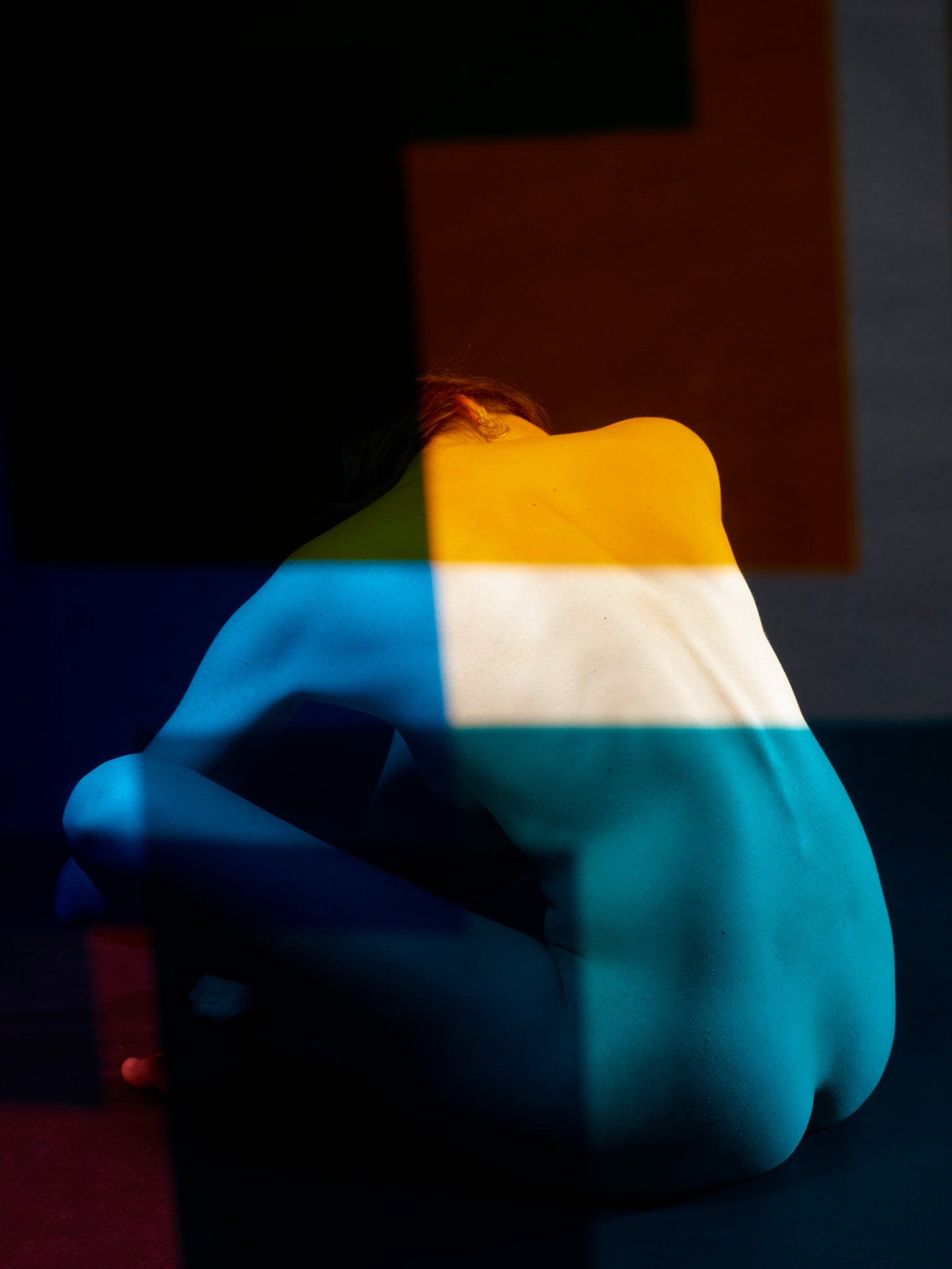 Photographie d’art d’André Wagner: La figure, penchée vers l’avant, est assise près du centre inférieur de l’image — Paula XIV.