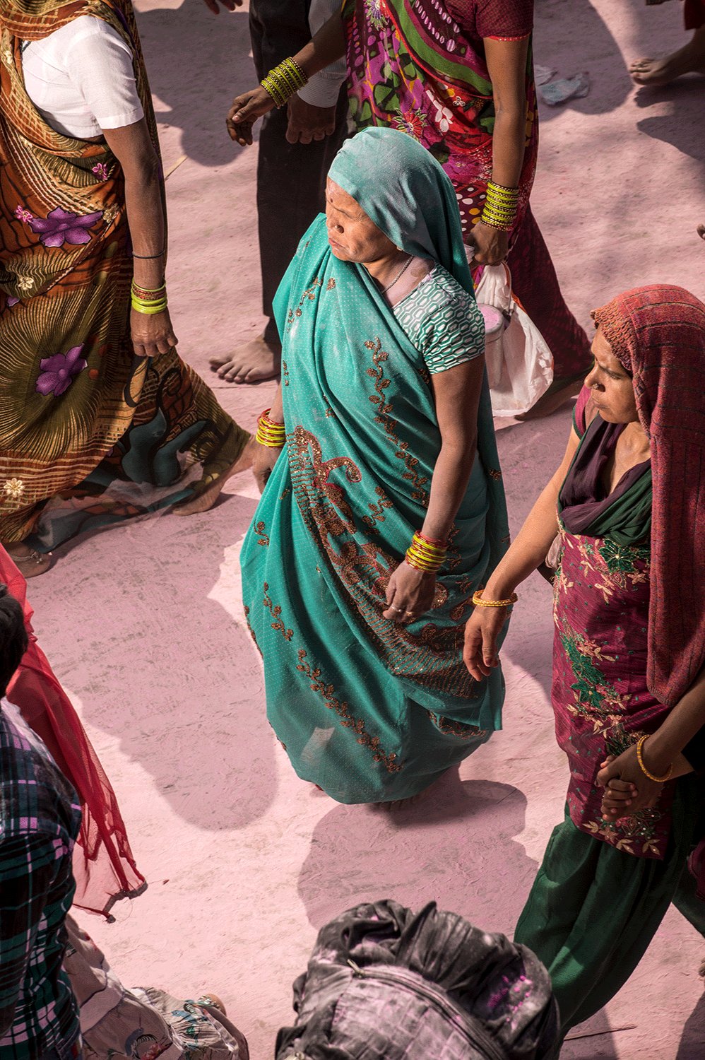Photographie d’art d’André Wagner: Vue d’en haut, une femme en sari turquoise se détache du sol rose — Pilgrim on purple dust 1, Indien.