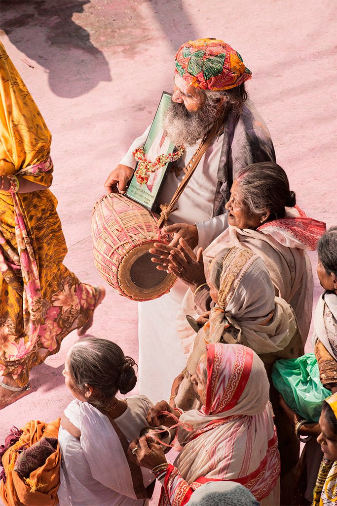 Photographie d&rsquo;art d&rsquo;Andr&eacute; Wagner: Un homme barbu coiff&eacute; d&rsquo;un turban &agrave; motifs color&eacute;s porte un grand tambour allong&eacute; devant son corps &mdash; Pilgrim on Purple Dust 14, Indien.