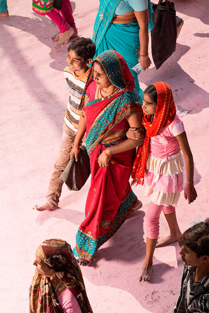 Photographie d’art d’André Wagner: Une femme vêtue de rouge, la tête couverte d’un foulard bleu-vert, marche près d’une personne plus petite en rose — Pilgrim on Purple Dust 8, Indien.