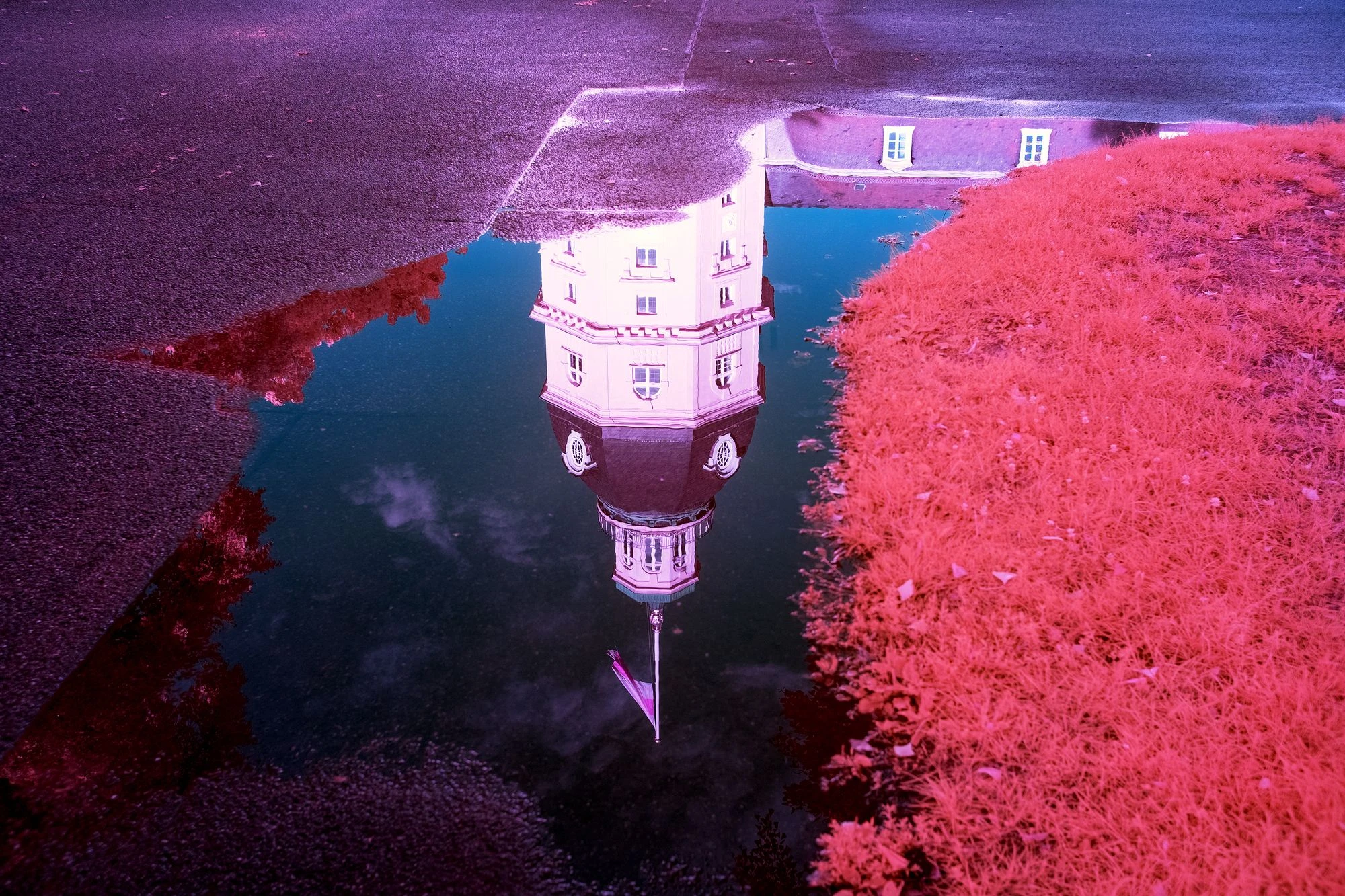 Photographie d’art infrarouge d’André Wagner: Une tour claire apparaît à l’envers dans une flaque sombre — Reflections of Karlsruhe.
