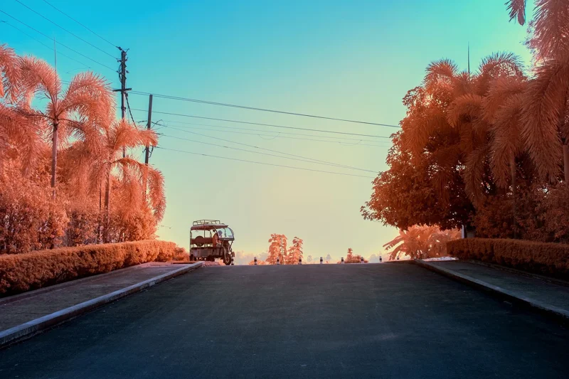 Photographie d’art infrarouge d’André Wagner: La route sombre monte vers une crête et disparaît derrière elle — Rickshaw - Gaura Village.