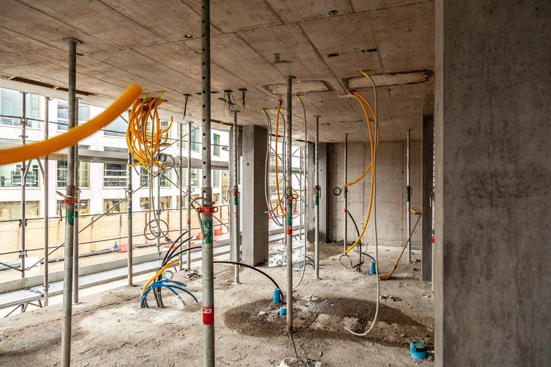 Unfinished building with columns, conduits and large window openings