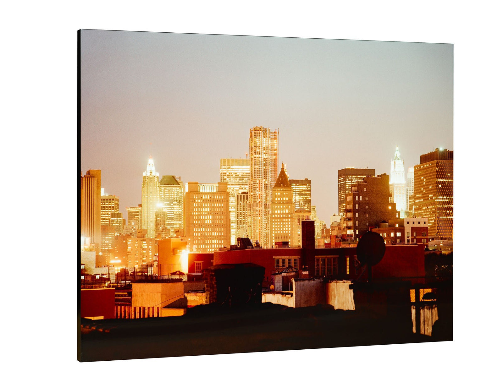 Photographie d’art d’André Wagner: Des tours éclairées s’élèvent derrière une zone sombre de toits et d’installations techniques — Room of business, Usa.