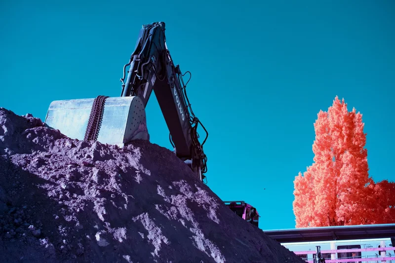 Photographie d’art infrarouge d’André Wagner: Un grand amas de terre gris-violet remplit le premier plan — The Last Dig.