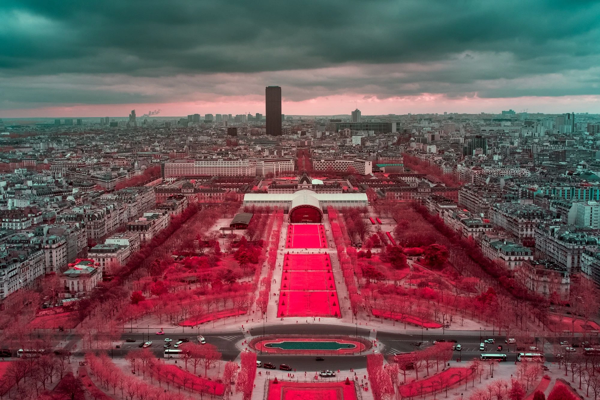 Photographie d’art infrarouge d’André Wagner: Depuis un point de vue élevé, un axe rouge lumineux traverse le tissu dense de Paris — The Red Carpet of Paris.