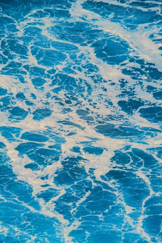 Photographie d’art infrarouge d’André Wagner: Un fin réseau d’écume claire recouvre une surface d’eau largement turquoise — The Restless Sea #3.