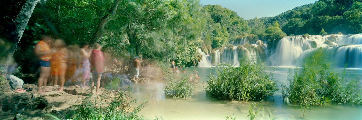 Photographie d’art d’André Wagner: Une large cascade traverse une végétation verte à l’arrière-plan — Time to Swim, Kroatien.
