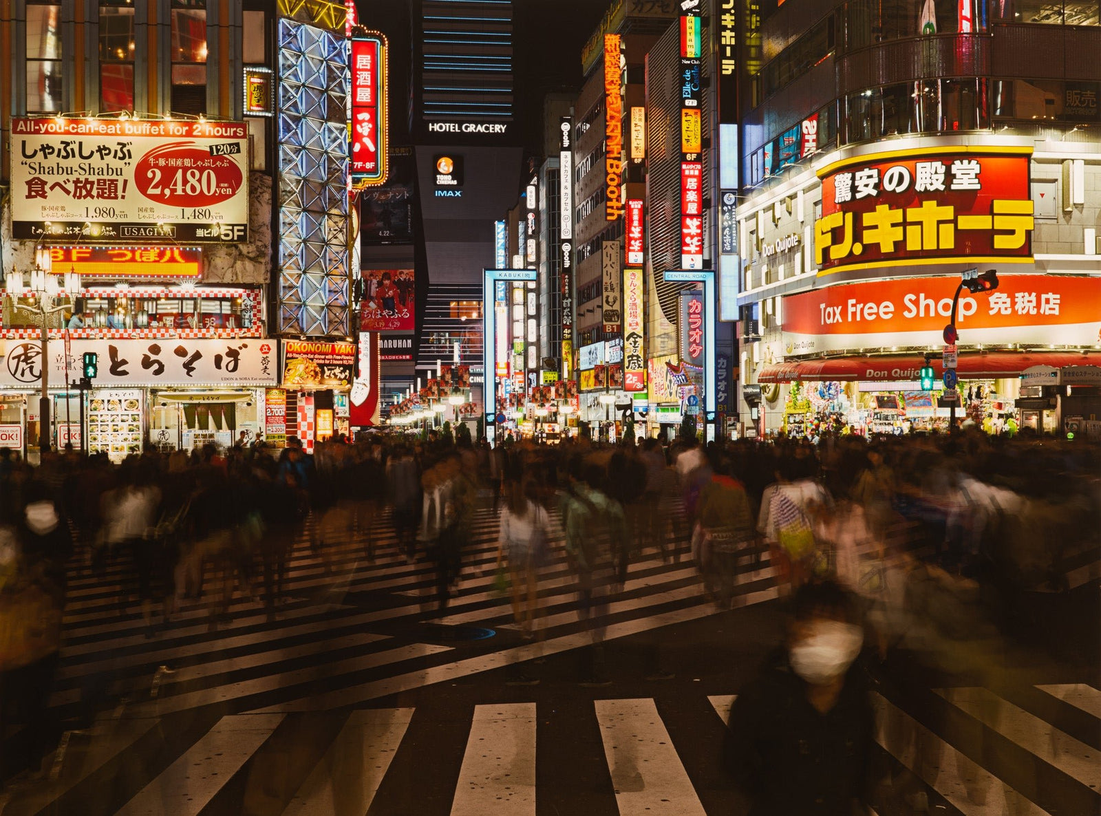 Photographie d’art d’André Wagner: Un large passage piéton conduit vers une rue encaissée, intensément éclairée — Tokyo shinjuku 2, Japan.