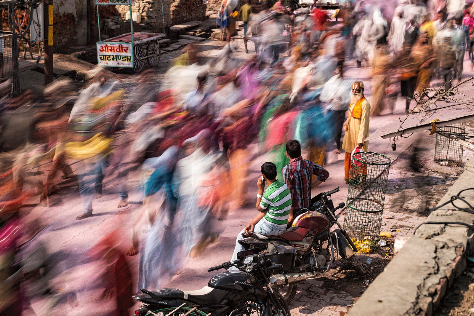 Photographie d&rsquo;art d&rsquo;Andr&eacute; Wagner: Un flot de personnes aux v&ecirc;tements color&eacute;s traverse une rue en diagonale &mdash; Vrindavan parikrama, Indien.