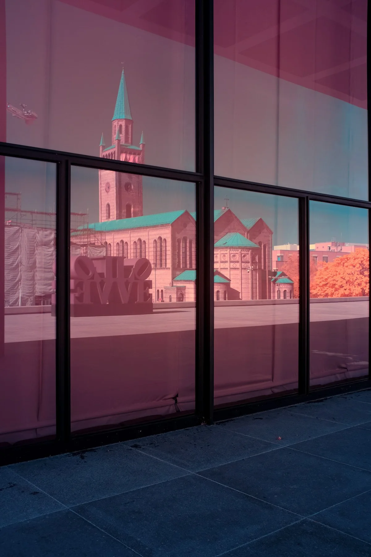 Historische Kirche spiegelt sich in einer Glasfassade.