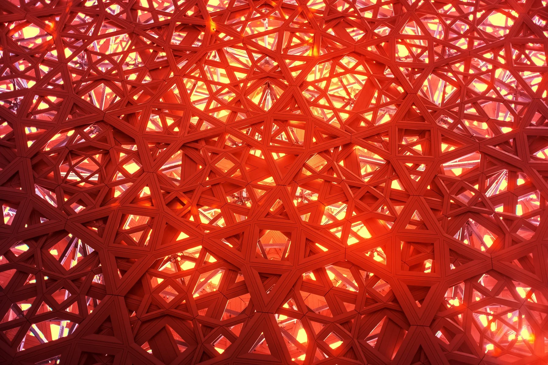 Sonnenlicht durch eine filigrane geometrische Dachstruktur.