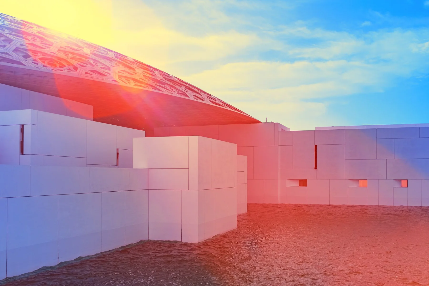 Sonnenreflexe &uuml;ber wei&szlig;en Museumsbauten am Wasser.