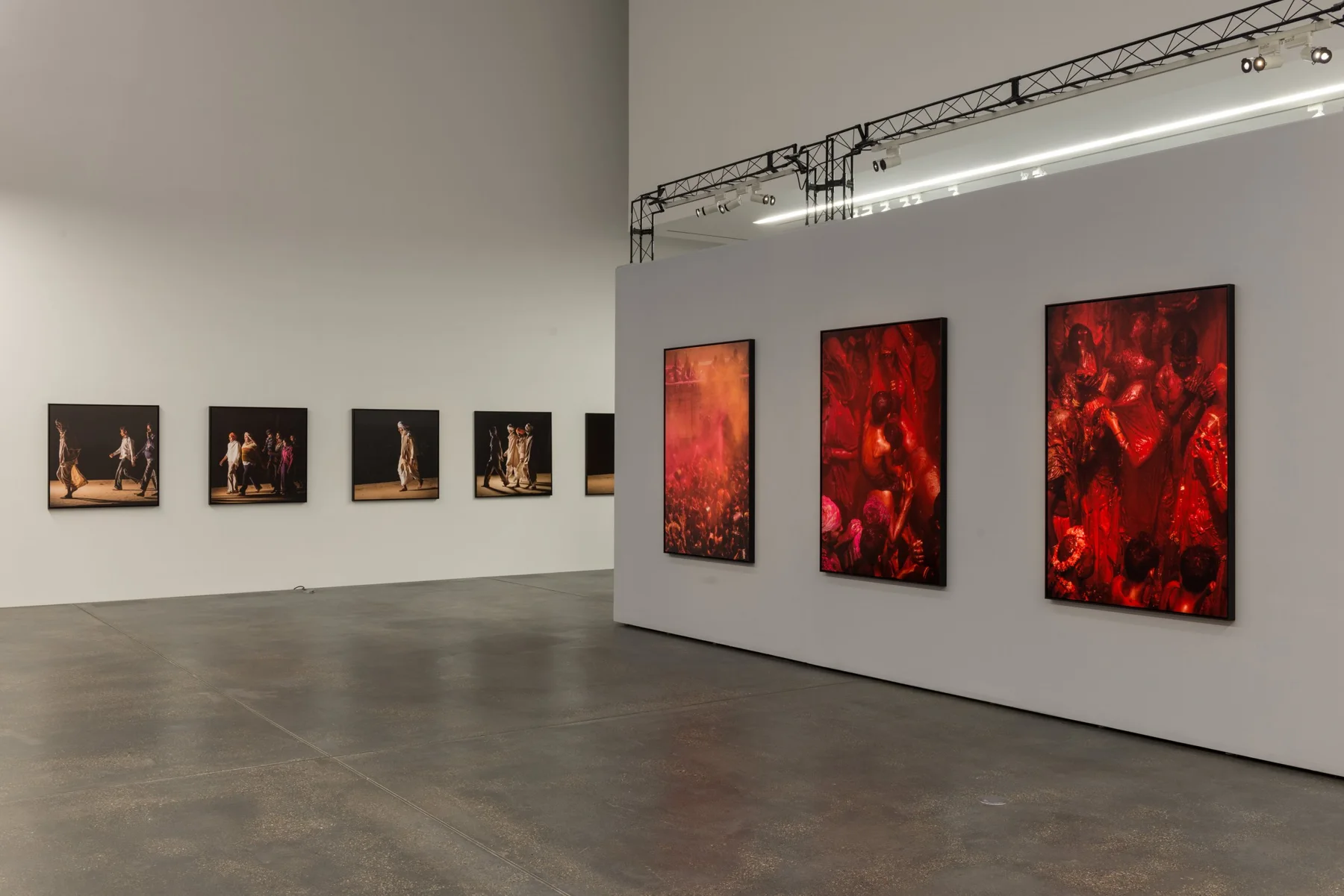 Musée d’art aux murs blancs, présentant plusieurs tableaux, dont des personnes dansant et un groupe représenté dans des tons rouges.