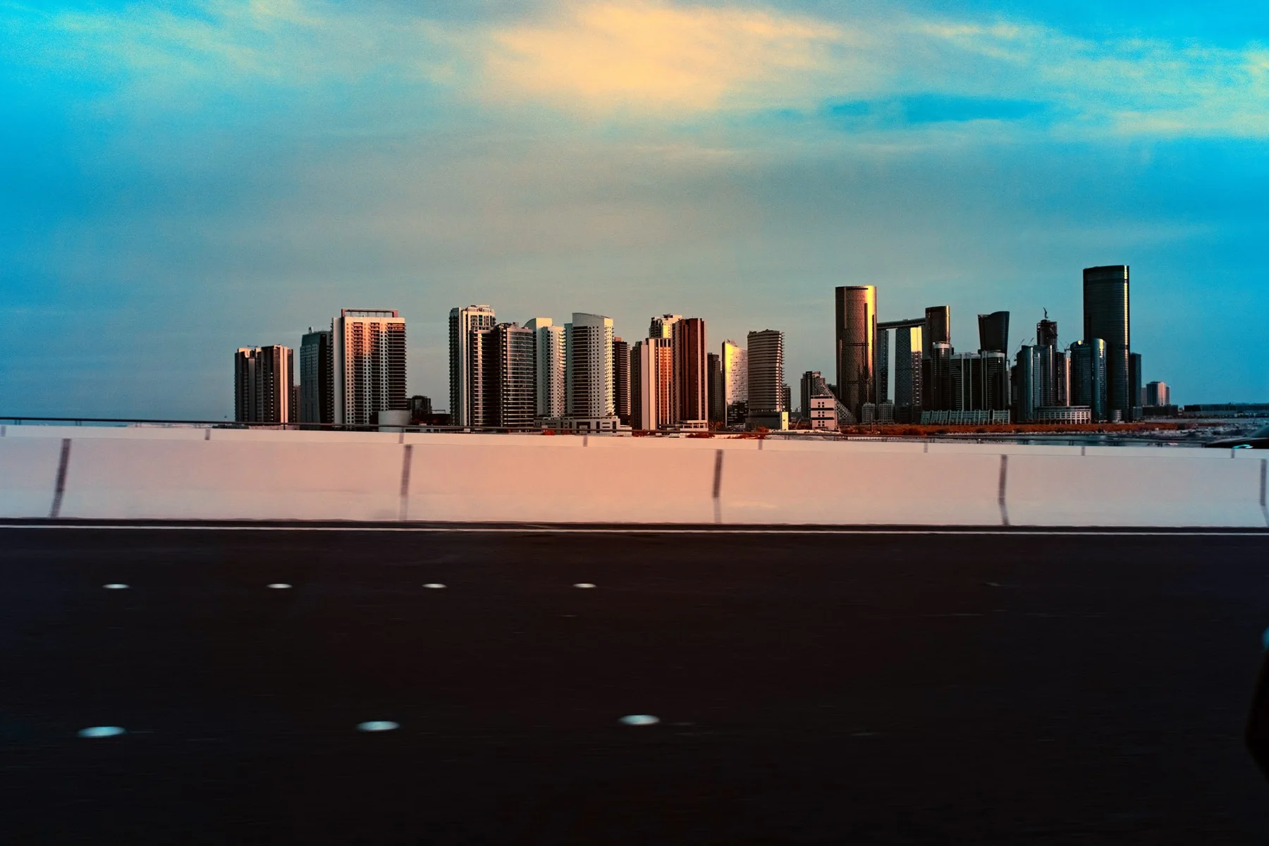 Skyline aus Hochh&auml;usern hinter einer Stra&szlig;e.
