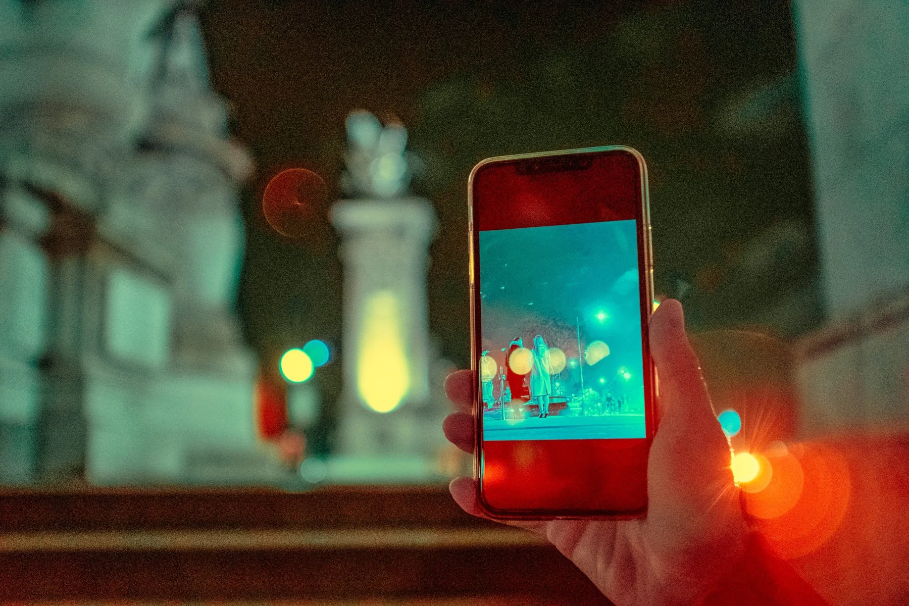 Ein Smartphone vor den Lichtern einer n&auml;chtlichen Stadt.